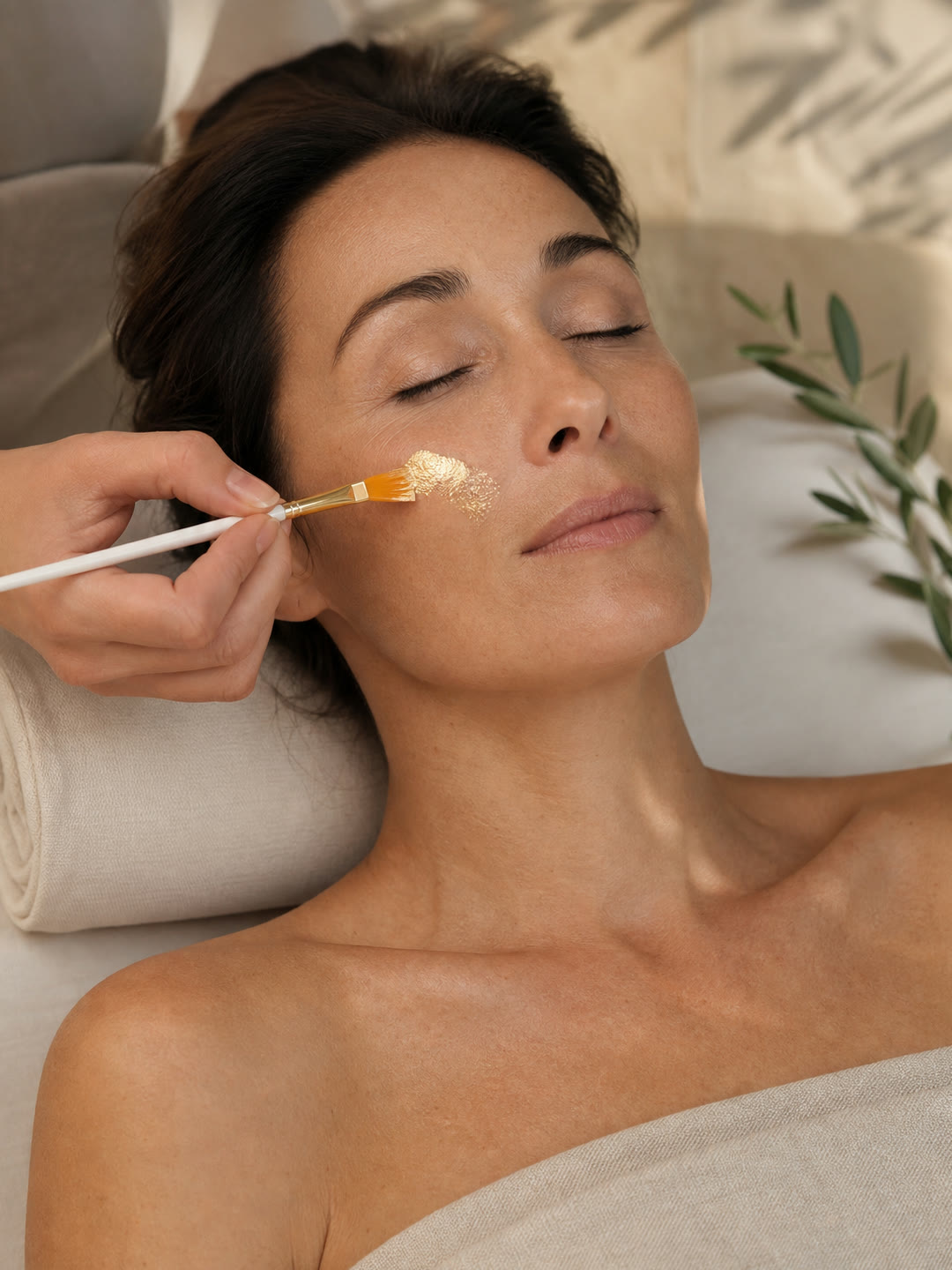 Soin du visage pour femme avec application précise d'une touche de feuille d'or